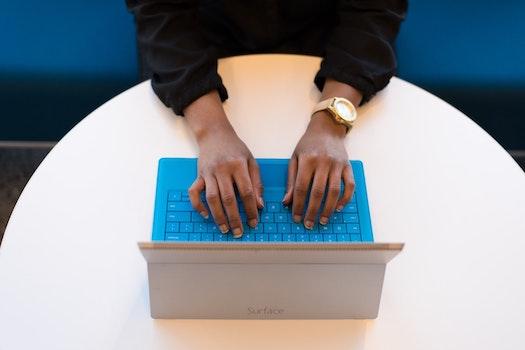 A student's hands on a keyboard, typing a personal essay.