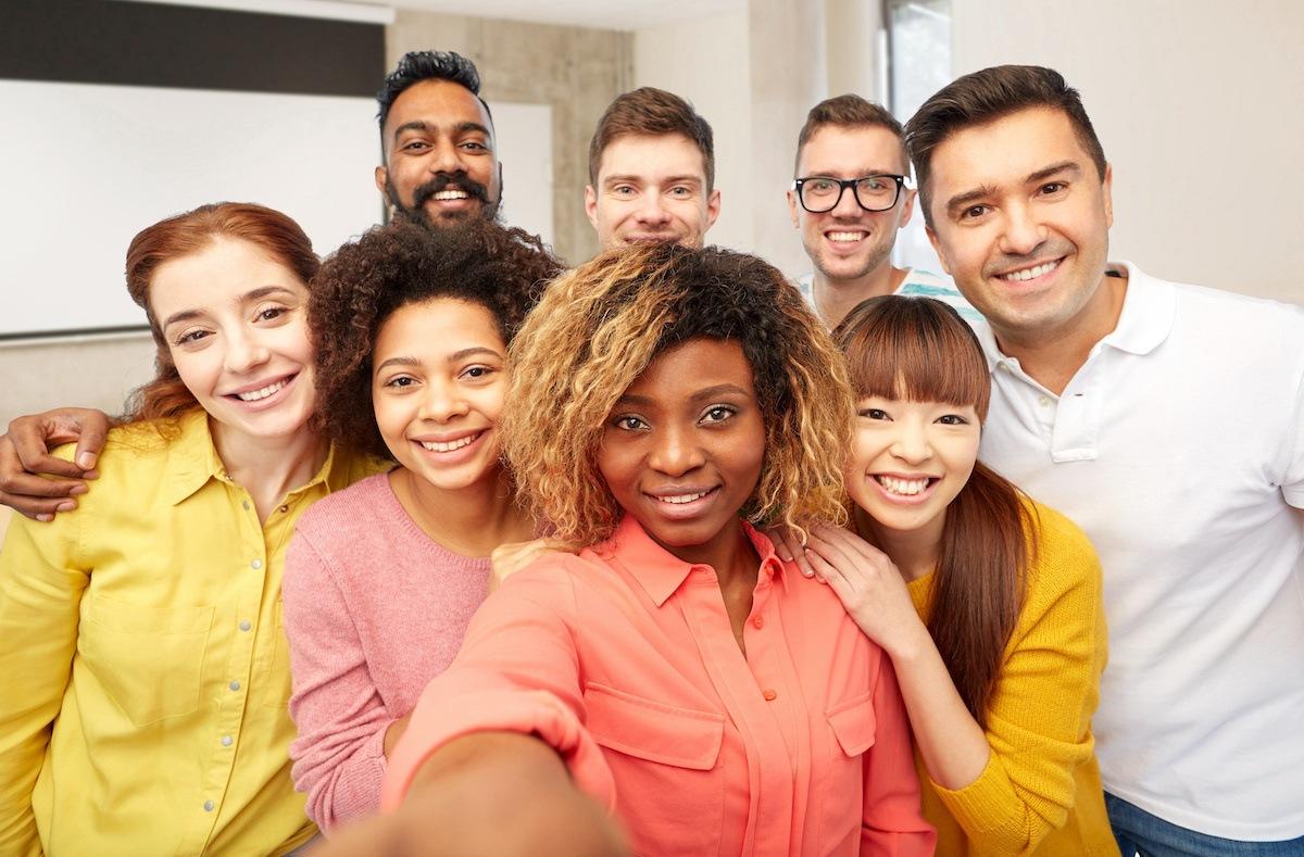 A group of eight diverse future South Carolina teachers gather for a group selfie. The person closest to the front holds out the camera in front of her to take the picture.